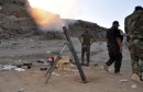 Members of Iraqi security forces and Shiite fighters fire a mortar during clashes with militants of the Islamic State, in Diyala province north of Baghdad