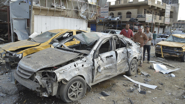 People gather at the site of a car bomb attack in Baghdad