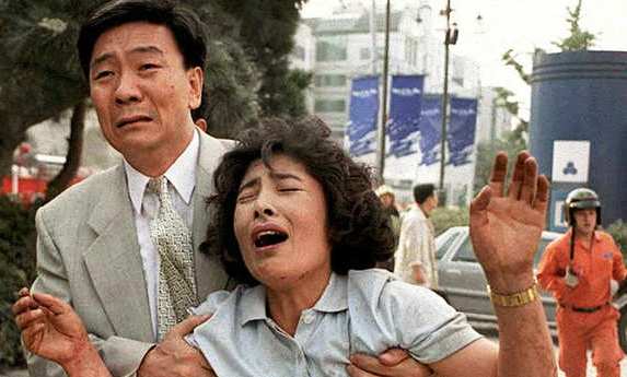 SEOUL, SOUTH KOREA - JUNE 29:  A frantic mother and her husband cry as they look for their missing daughter after an explosion and the collapse of the Sampoong Department store building in southern Seoul 29 June. At least 20 people were killed and hundreds hospitalized as rescue crews continued to dig for survivors.   AFP PHOTO  (Photo credit should read CHOO YOUN-KONG/AFP/Getty Images)