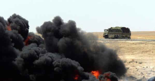 An Iraqi lorry passes by the the raging fire on Iraq's key oil export pipeline to Turkey two days after an act of sabotage in Baiji, a town about 200 kilometres (125 miles) north of Baghdad, 17 August 2003. "The damage to the pipeline means seven million dollars losses every day," said the US civil administrator for Iraq, Paul Bremer.  AFP PHOTO/MAXIM MARMUR  (Photo credit should read MAXIM MARMUR/AFP/Getty Images)