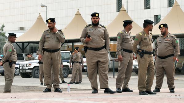 Saudi policemen stand guard in front of