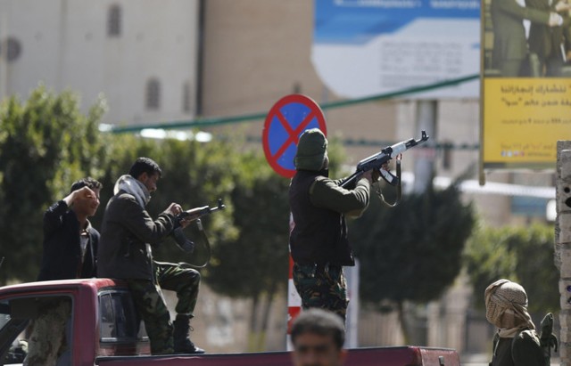 A Houthi fighter fires at forces guarding the Presidential Palace during clashes in Sanaa