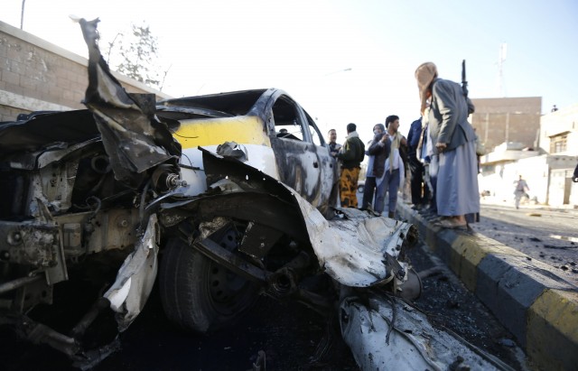 Policemen gather at the scene of a car bomb attack outside a police college in Sanaa