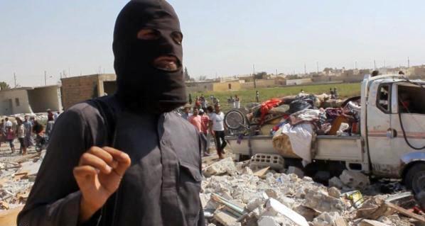 An image grab taken from an AFPTV video on September 16, 2014 shows a jihadist from the Islamic State (IS) group standing on the rubble of houses after a Syrian warplane was reportedly shot down by IS militants over the Syrian town of Raqa. The plane crashed into a house in the Euphrates Valley city, the sole provincial capital entirely out of Syrian government control, causing deaths and injuries on the ground. AFP PHOTO / AFPTV / STR        (Photo credit should read -/AFP/Getty Images)