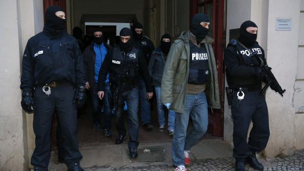 German special police units leave an apartment building in the Wedding district in Berlin