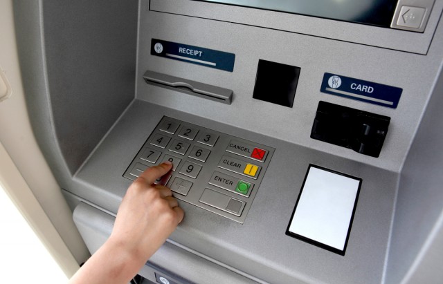 A woman's hand using a cash machine (ATM)