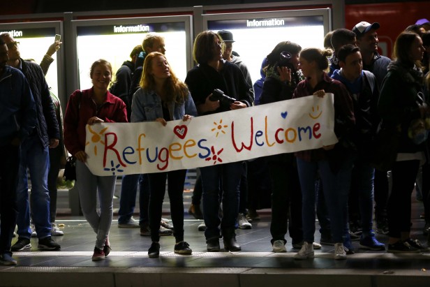 Wellwishers hold a placard as a train arrives at the railway station in Frankfurt