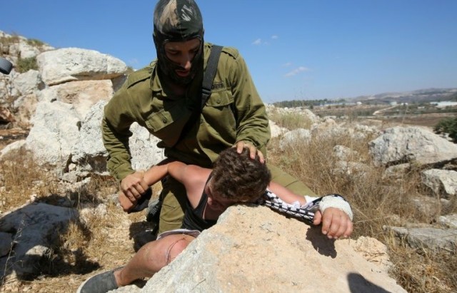 un-soldat-israelien-plaque-un-enfant-palestinien-sur-un-roch_2239042