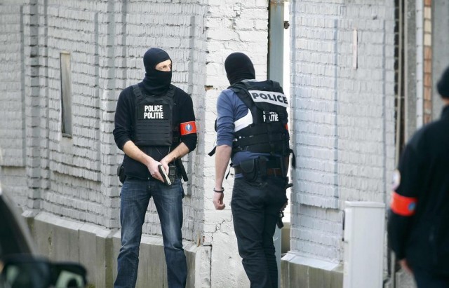 Police at the scene where shots were fired during a police search of a house in the suburb of Forest near Brussels, Belgium, March 15, 2016.