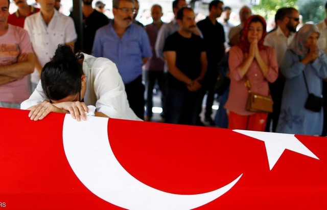 A relative of a victim of Tuesday's attack on Ataturk airport mourns at her flag-draped coffin during her funeral ceremony in Istanbul