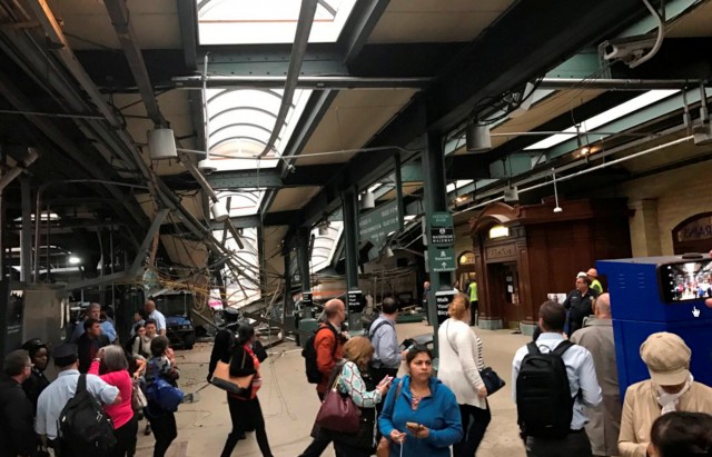 Onlookers view a New Jersey Transit train that derailed and crashed through the station in Hoboken