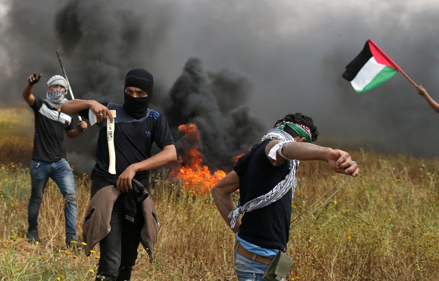 Palestinian demonstrator holds an axe during clashes with Israeli troops, during a tent city protest along the Israel border with Gaza, demanding the right to return to their homeland, the southern Gaza Strip