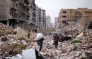 People walk amid the rubble as they carry belongings that they collected from their houses in the government controlled area of Aleppo