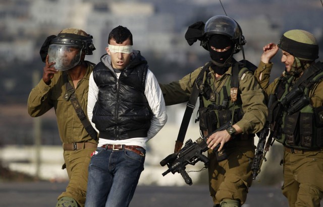 Israeli soldiers arrest Palestinian during clashes with Israeli troops at protest against Jewish settlement of Ofra near Ramallah