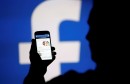 FILE PHOTO: A man is silhouetted against a video screen with an Facebook logo as he poses with an Samsung S4 smartphone in this photo illustration taken in the central Bosnian town of Zenica