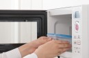 Hand using a microwave oven