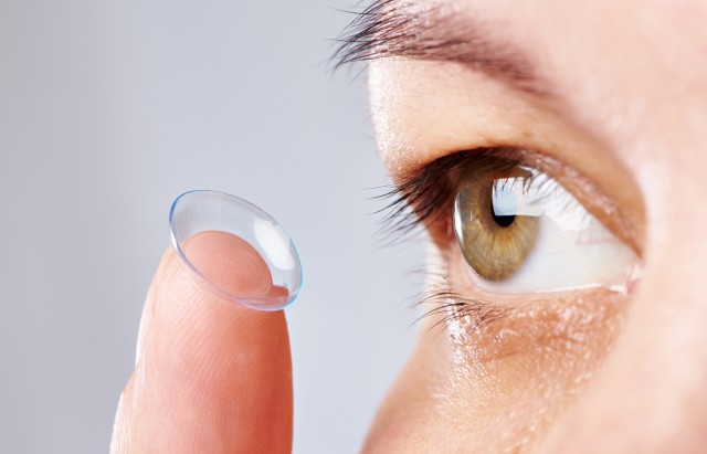 Young womans eye and contact lens