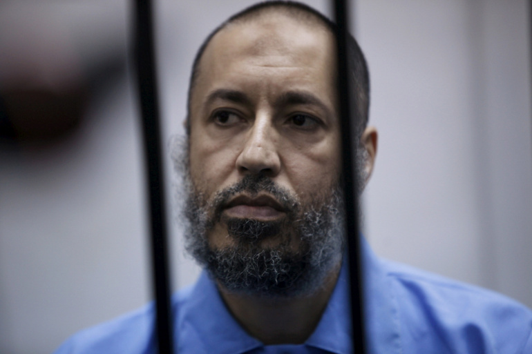 FILE PHOTO: Saadi Gaddafi, son of Muammar Gaddafi, sits behind bars during a hearing at a courtroom in Tripoli, Libya